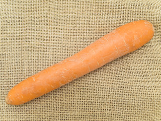 Single carrot at the brown linen