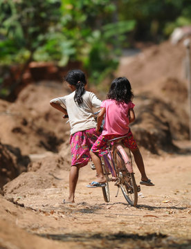 two cambodian kids on one bicycle