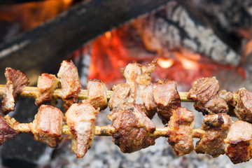 Pork pieces on wooden stick (traditional  shish kebab) roasting