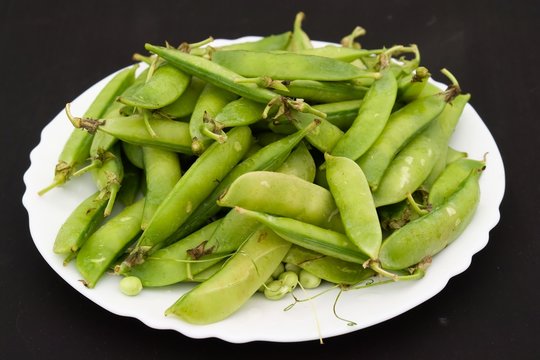 Peas pods on a white plate