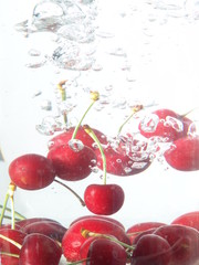 Fototapeta na wymiar Cherries falling in water