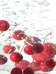 Fototapeta na wymiar Cherries falling in water