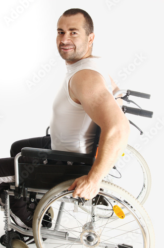 A person is smiling while sitting in a wheelchair
