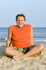 A happy laughing forties man on beach.