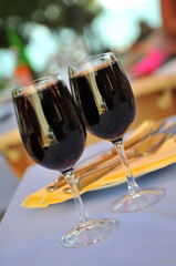 two glasses in outside restaurant with black wine