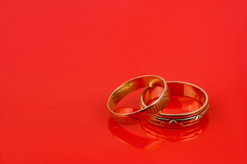 Gold wedding rings on red