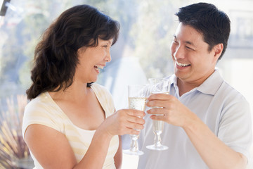 Fototapeta na wymiar Couple toasting champagne and smiling