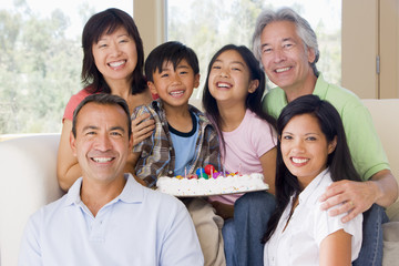 Obraz premium Family in living room with cake smiling