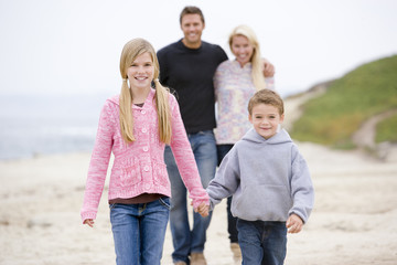 Fototapeta na wymiar Family walking at beach holding hands smiling