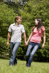 Couple walking outdoors holding hands smiling