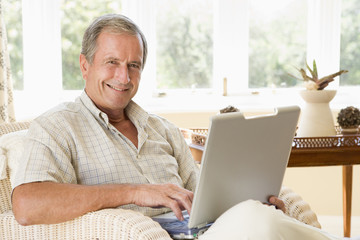 Man in living room with laptop smiling