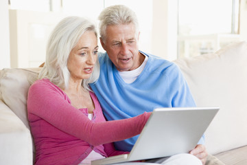 Couple in living room with laptop smiling
