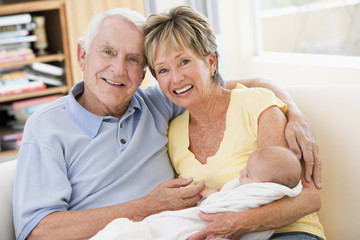 Grandparents in living room with baby smiling