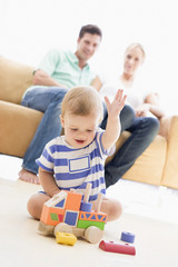 Couple in living room with baby smiling