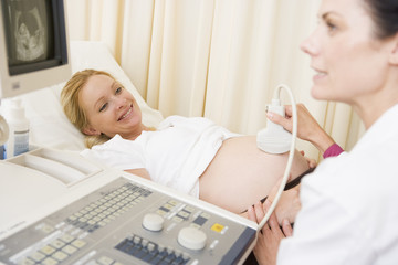Pregnant woman getting ultrasound from doctor
