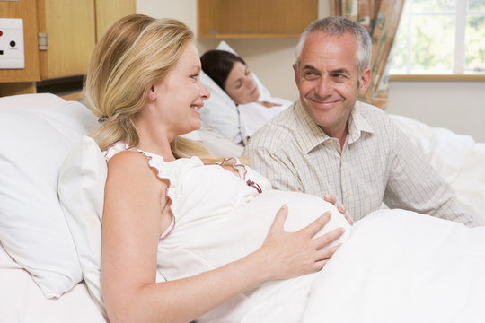 Pregnant woman with husband in hospital smiling