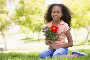 Young girl holding flowers and smiling