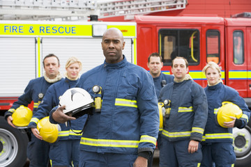 Portrait of a group of firefighters by a fire engine