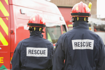 Firefighters standing by a small fire engine