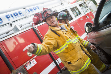 Firefighters cutting open a car to help an injured person