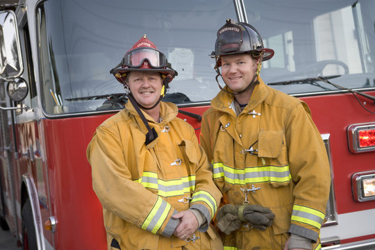 Portrait Of Two Firefighters By A Fire Engine