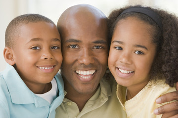 Man and two young children embracing and smiling