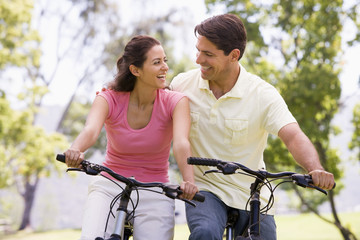 Obraz premium Couple on bikes outdoors smiling
