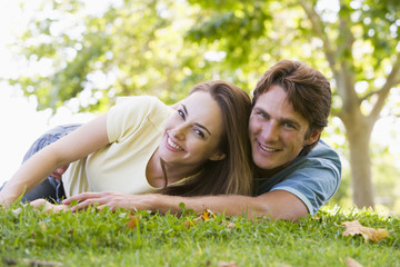 Couple lying outdoors smiling