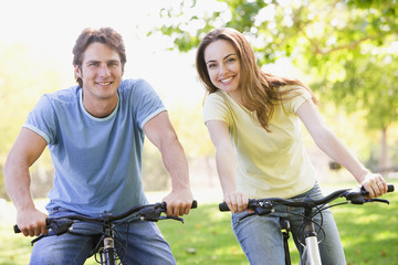 Couple on bikes outdoors smiling
