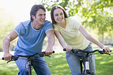 Obraz premium Couple on bikes outdoors smiling