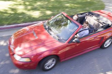 Couple in convertible car smiling