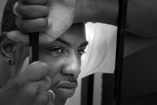 Face Of An Angry African American Man Behind Iron Bars