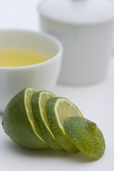 Tea serving in white cup with spoon and lime sliced