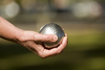 main tenant une boule de pétanque