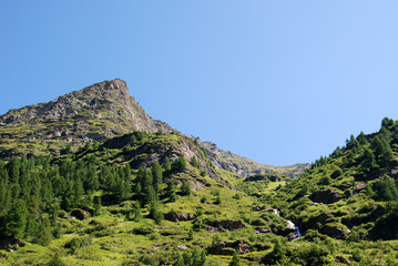 Fototapeta na wymiar High mountain scene, waterfall, blue sky, Switzerland, Ticino