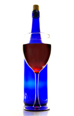 glass of red wine, and blue bottle, on white