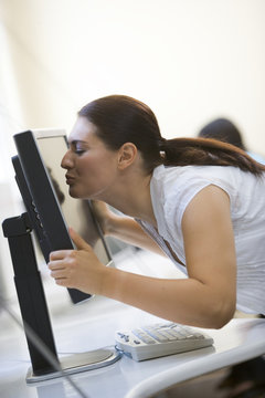 Woman In Computer Room Kissing Monitor