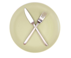 fork and knife on green plate isolated on white