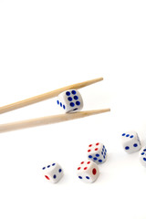 Chopsticks and dices on white background