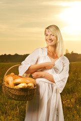 Beautiful young woman with a basket full of fresh baked bread