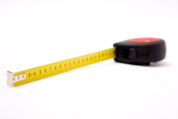 Measuring yellow tape tool over white background