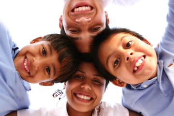 Happy Family of Four Looking Down with Heads Together