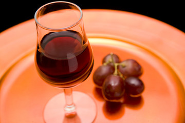 Red wine and red grapes on a tray