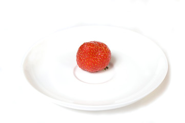 Ripe single strawberry in a plate, isolated on white