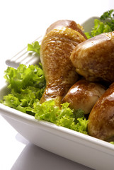 some roasted chicken legs over lettuce