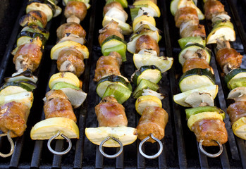 Sausage shish kebabs on skewers, cooking on the grill.