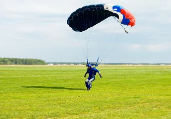 Tuinposter Landing of the sportsman after parachute jump © Aleksey Dmetsov