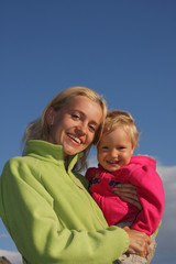 Happy mum with a daughter against the sky