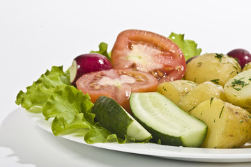 tasty boiled potatoes with tomato, radish and lettuce