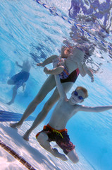 Family at swimming pool, underwater shot